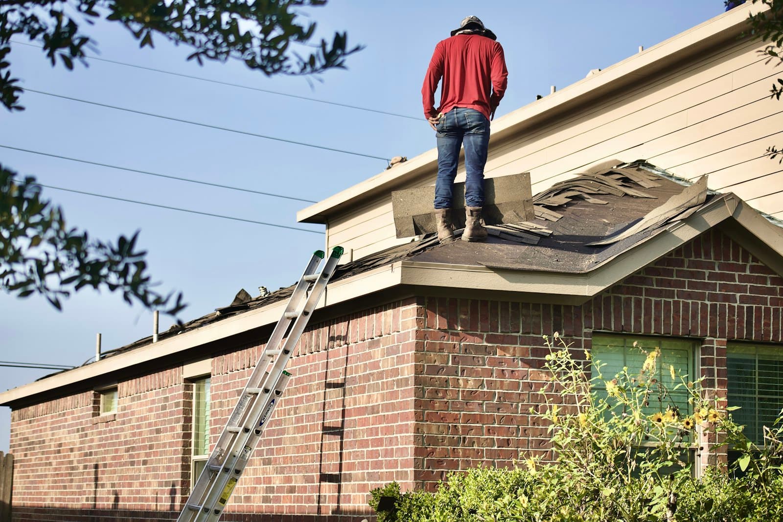Roofer inspecting a shingle tear-off